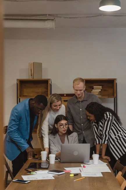 Team members discussing digital graphs on a tablet in a modern office setting.